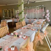The function room set up for a celebration with peach tulle, balloons and a long banquet table