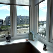 Bay window onto Strand Quay and the River Tillingham, with a model boat and beach hut on the sill