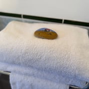 Folded towels with a hand-painted Rye pebble in the twin-room en-suite